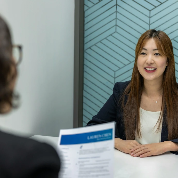 a woman sitting at a table with a piece of paper in front of her